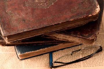 Poster - Old worn shabby leather-bound jewish books on open blurred Torah in the background. Closeup. Selective focus.