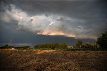 Wall Mural - Dramatic sky with thunderstom over small village in Transylvania.