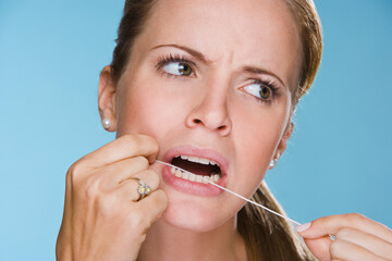 Wall Mural - Young woman flossing her teeth