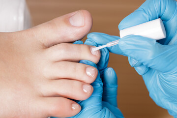 Sticker - pedicure master applies colorless nail polish