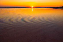 Sunset Over The Lake. Sunset Background Photo With Calm Waves Over The Lake