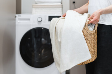 Wall Mural - Woman with laundry basket standing against washing machine