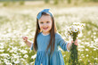 © morrowlight - Smiling cute baby girl 3-4 year old wear stylish dress holding flower in blooming meadow outdoor. Childhood. Summer season.