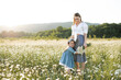 © morrowlight - Pretty woman holding kid girl 3-4 year old standing in camomile meadow over nature background outdoor. Mother with little child together. Motherhood. Family lifestyle concept.