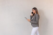 © Hugo - Beautiful business girl walking while talking on phone and using tablet on white background.