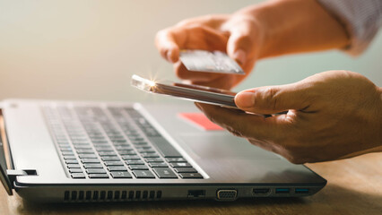 Wall Mural - Businessman using laptop computer with a credit card making an online order. Business, online shopping, e-commerce, internet banking, spending money, online payment, working from home concept.