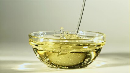 Poster - olive oil flows into a glass bowl. on a white background. filmed is slow motion 1000 fps. high quali