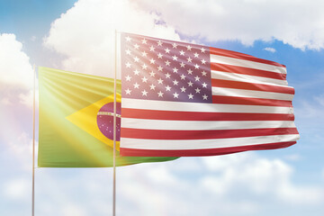 Wall Mural - Sunny blue sky and flags of united states of america and brazil