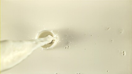 Canvas Print - A stream of milk pours in with splashes. The texture of milk. Filmed on a high-speed camera at 1000 fps.