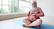 Young pregnant Muslim woman doing pilates in gym