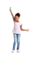 Little African-American girl with maracas on white background