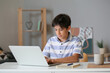 © Pixel-Shot - Teenage boy learning with laptop at home
