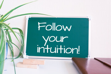 Wall Mural - Text Follow your intuition written on the green chalkboard