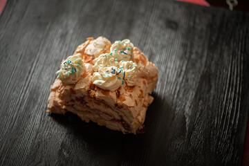 A piece of delicious organic homemade biscuit cake, on a wooden background close-up.