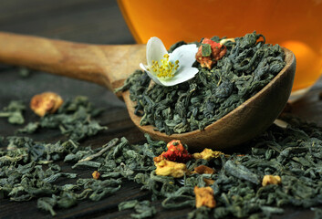 green tea with jasmine on the table. green tea leaves, jasmine flowers and cup of tea close-up.