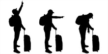 A Group Of Tourists Stands In One Line. The Man Points His Finger Up, Down, Sideways. A Guy Of A Large Build In A Cap, With A Backpack Behind His Back And Luggage On Wheels In His Hands. Side View.