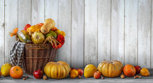 Thanksgiving Day Background With Empty Copy Space. Pumpkin Harvest In Wicker Basket. Squash, Orange Vegetable Autumn Fruit, Apples, And Nuts On A Wooden Table. Halloween Decoration Fall Design