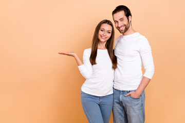 Poster - Photo of lovely millennial brunette couple hold empty space wear white cloth isolated on beige color background