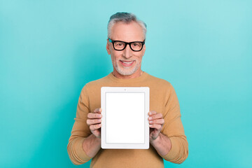 Photo of cheerful person hold demonstrate empty space tablet screen isolated on turquoise color background