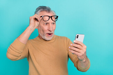 Wall Mural - Portrait of positive astonished person hand touch eyewear read impressed news isolated on teal color background