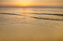 Calm Ocean Surf Washing Up Onto Beach At Sunrise