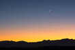 © Tetra Images - USA, New Mexico, Santa Fe, Jemez Mountains at dusk with crescent moon on sky