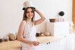 Young Housewife in Playful Mood. Woman Jokingly Put Saucepan on Her Head with Whisk in Her Hands
