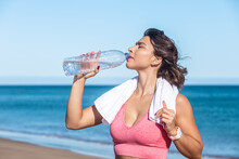 Female Athlete Drinking Water From Bottle After Workout