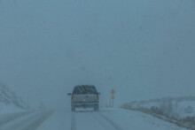 USA, Idaho, Fairfield, Pick-up Truck On Snow Covered Highway 20 In Rural Landscape