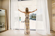 © Tetra Images - Rear view of woman looking out of bedroom window