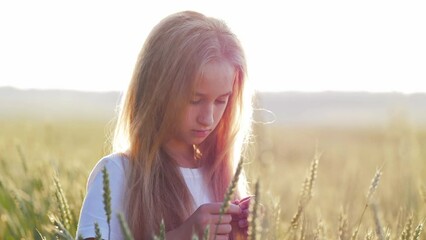 pretty child in the wheat field. happy young girl play in the field at sunset. happy kid playing in 