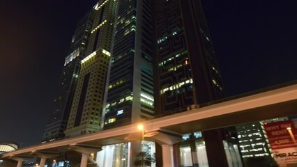 Wall Mural - DUBAI, UAE - DECEMBER 5, 2016: Walking along Dubai Marina at night with skyscrapers lights