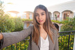 © Hugo - Selfie of a serious business girl on a hotel balcony.