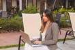 © Hugo - Business girl working with her laptop in a hotel courtyard.