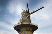 Low Angle Of A Medieval Windmill With Sails On The Sky Background