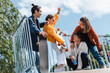 © LIGHTFIELD STUDIOS - excited woman showing win gesture near multiethnic skaters in skate park.