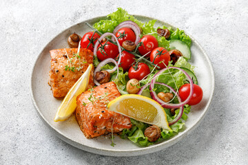 Wall Mural - Salmon fish fillet and fresh green vegetable salad with lettuce, cherry tomatoes, onion, mushrooms. Close up.