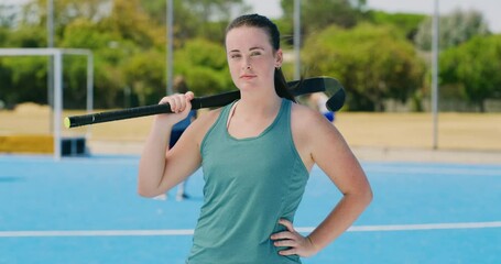 Sticker - Portrait of a young hockey teenager holding a stick and standing on astroturf pitch. Serious sports player feeling confident, powerful and motivated in training. Young high school girl ready for match