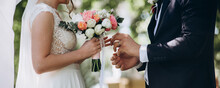 Groom Put A Ring On Finger Of His Lovely Wife. Wedding Engagement Rings. Married Couple Exchange Wedding Rings At A Wedding Ceremony. Concept Wedding Details. Happy Family. Together.