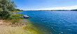 Summer panoramic lakeview with clear blue sky and water, sunbatch platform at Karsko Wielkie lake, picture taken from a shallow lakeshore, Poland