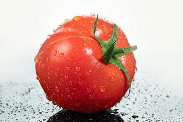 Ripe red tomato with drops of water on the skin