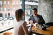 © Drazen - Happy businessman talks with female colleague during breakfast in cafe.