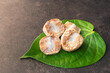 Betel nut or areca nut with betel leaf isolated on dark background.