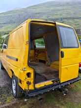 A Yellow Abandoned Transporter Car With A Missing Door In The Back.