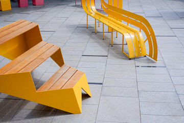 High angle view of empty yellow modern bench on gray marble tile floor in public rest area