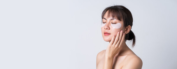 banner, portrait posing asian woman applying patches mask under eyes for anti wrinkles and eye dark 