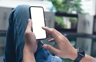 Wall Mural - Mockup image of mobile phone for advertising. Mock up image of man hand holding and using smartphone with blank screen for mobile app design or text advertisement