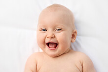 Close-up Portrait Of Laughing Blue-eyed Baby
