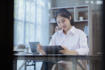 Wall Mural - Asian women working in the office, young Asian business women as business executives, founding and running start-up executives, young female business leaders. Startup business concept.