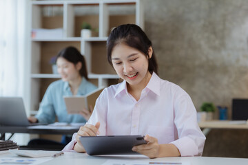 Wall Mural - Asian women working in the office, young Asian business women as business executives, founding and running start-up executives, young female business leaders. Startup business concept.